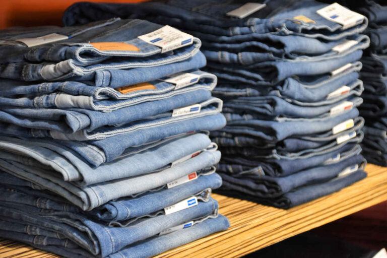 Stapels jeans met verschillende maten waarvoor je in het voorraadbeheersysteem maatbalken kunt gebruiken