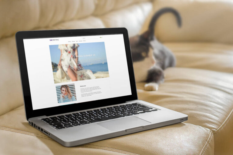 Voorbeeld SW-Retail webshop thema op een laptop die op een bank ligt met een kat ernaast